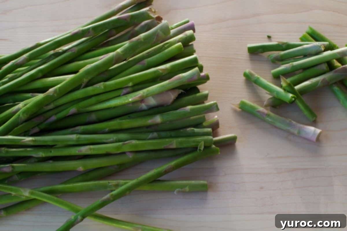 ends of asparagus broken off on a cutting board