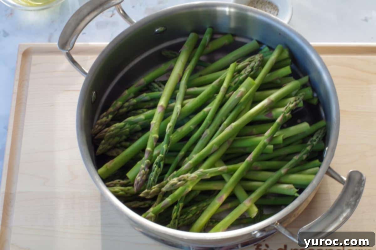 steamed asparagus in a steamer on a cutting board