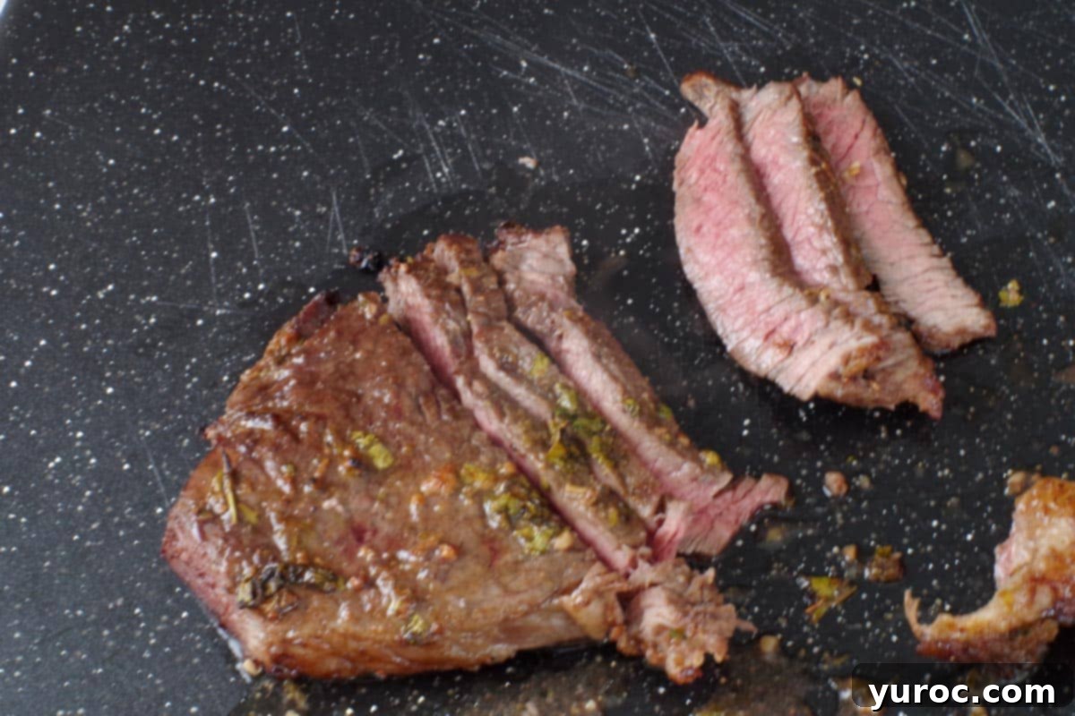 steak being sliced ¼ inch thick on a cutting board