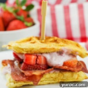 A delicious and healthy chicken and waffle sandwich with fresh strawberries in the background, perfect for a balanced meal.