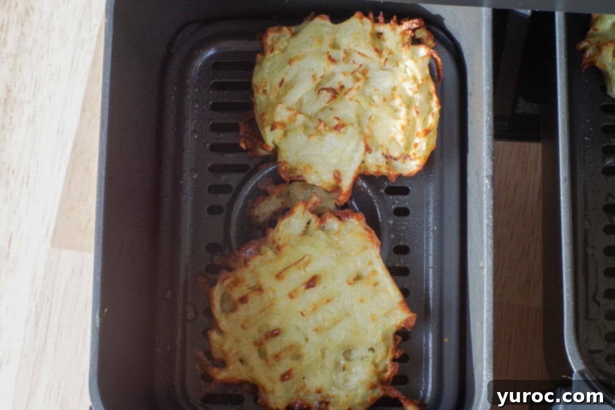 Air fryer potato pancakes cooked on both sides in air fryer drawer