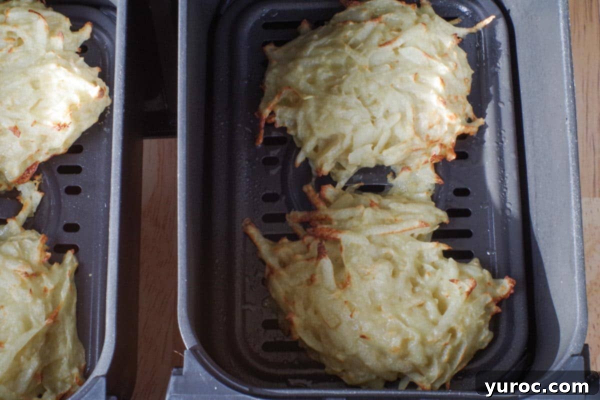 air fryer potato pancakes cooked on one side in air fryer drawers