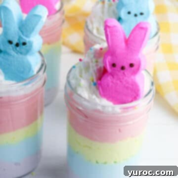 A quartet of festive Jello Easter Pie Jars, perfectly arranged with a yellow and white checkered towel framing the right side.