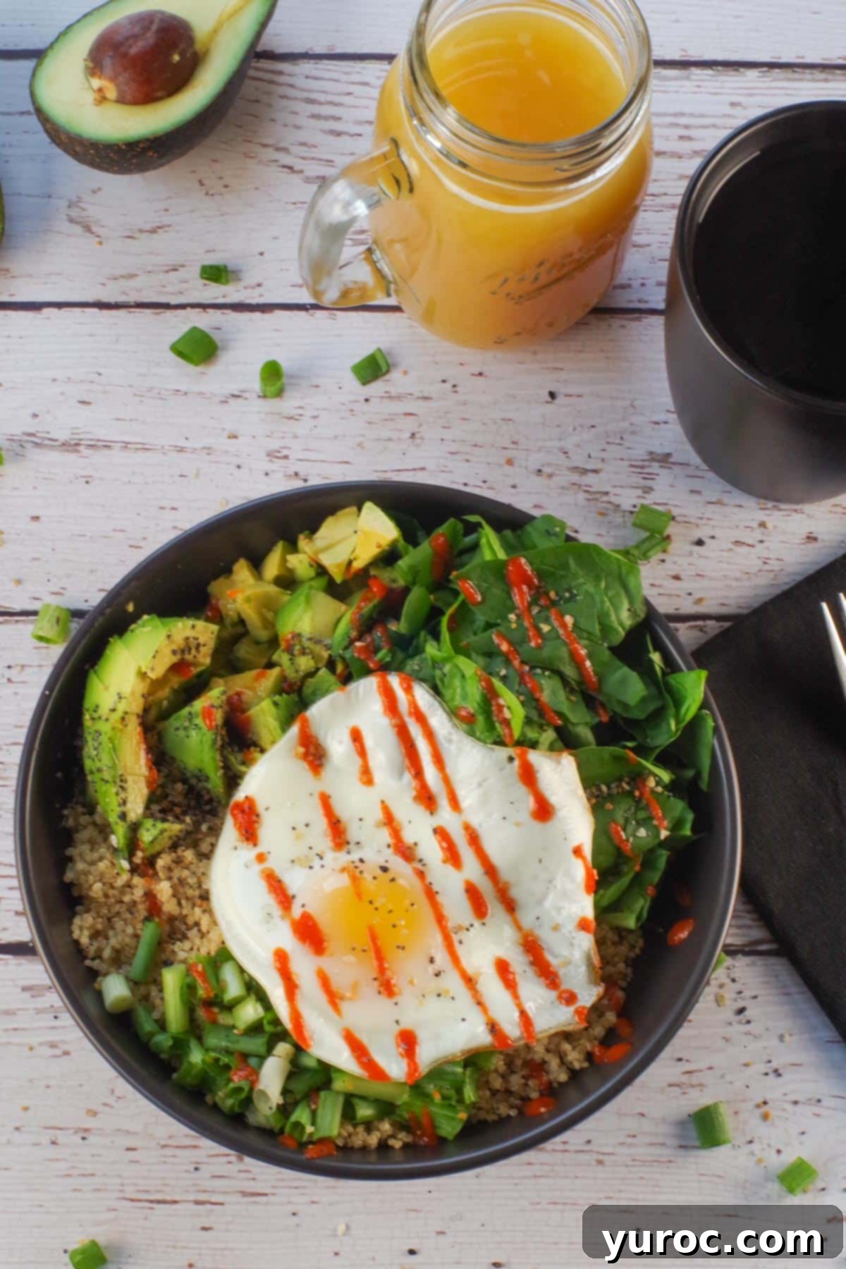 Avocado Breakfast Power Bowl 12 Avocado breakfast bowl in a black bowl with coffee and juice in the background and black linen napkin with fork, on right side