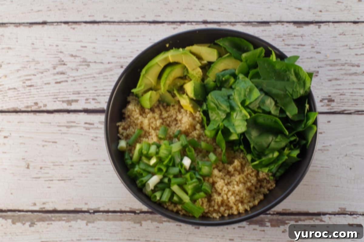 Avocado Breakfast Power Bowl 6 avocado added to bowl with quinoa, spinach and green onion