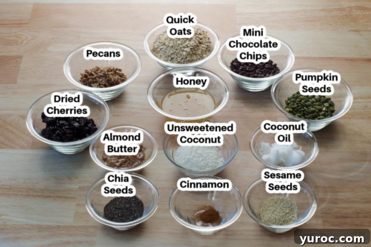 Various ingredients for Almond Butter Granola Bars displayed in clear glass bowls, each clearly labeled for easy identification.