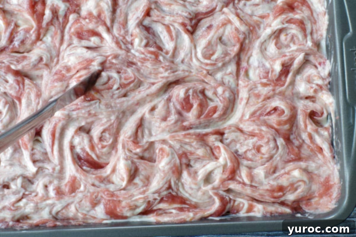 knife swirling rhubarb mixture into cream cheese mixture