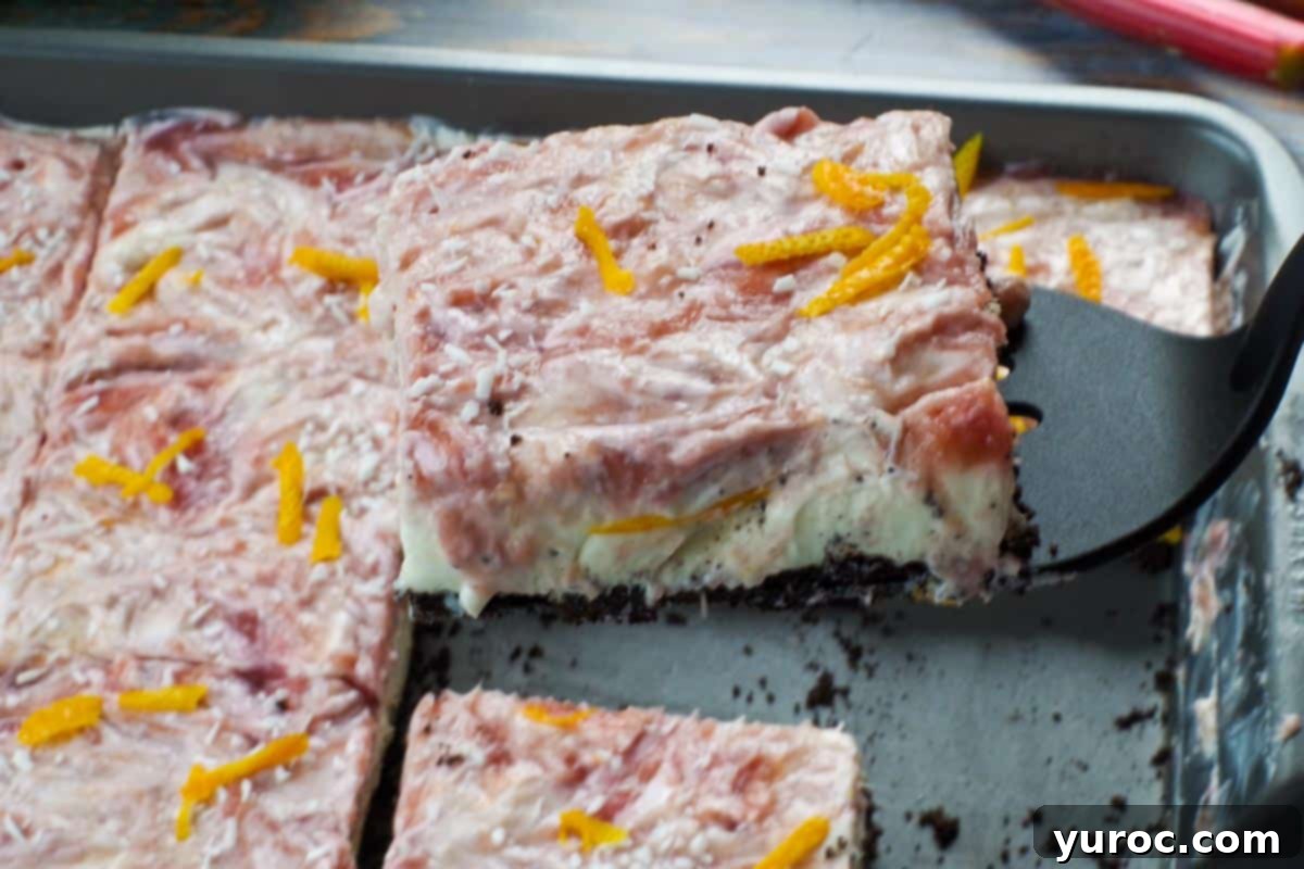 rhubarb bar being lifted out of pan with black spatula