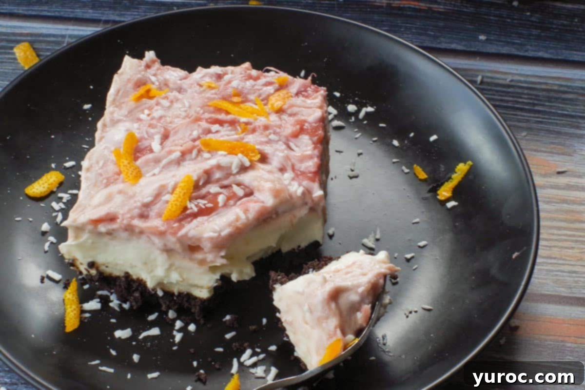 rhubarb cream cheese bar on a black plate being cut into with a fork (and a bite of the bar on the fork)