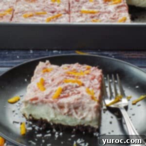 slice of rhubarb cream cheese bar on a black plate with a tray of more in the background