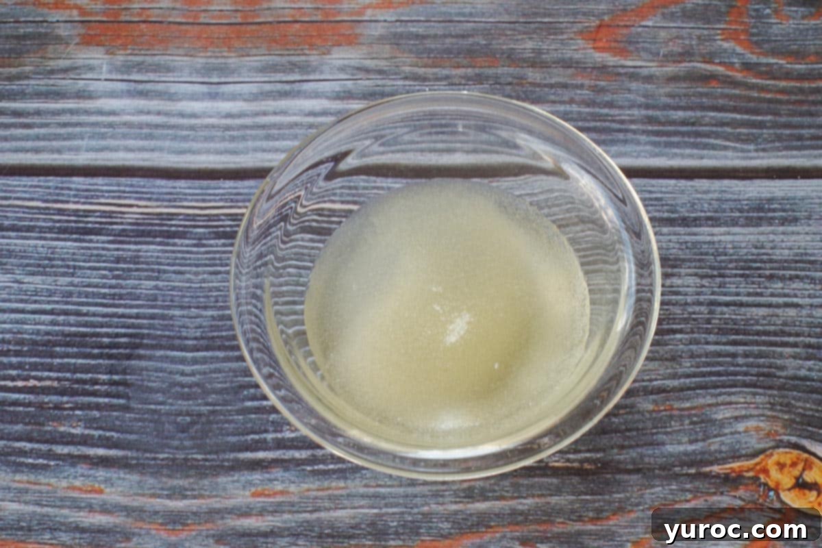 gelatin sprinkled over water in small glass bowl