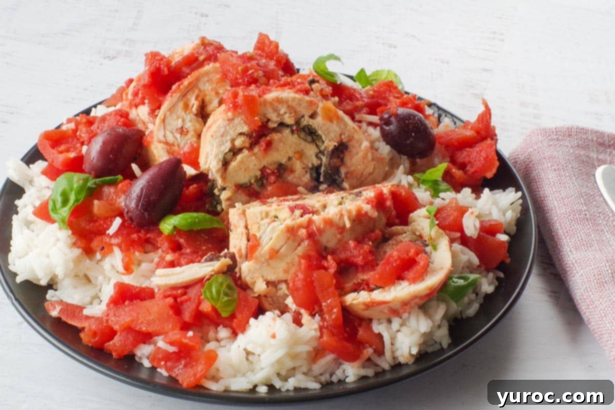 Mediterranean Slow Cooker Stuffed Chicken breast on rice, on a black plate
