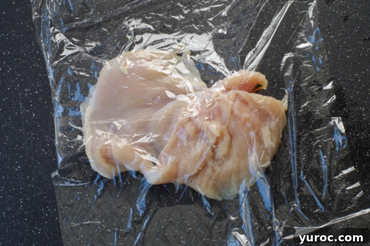chicken breast under saran wrap