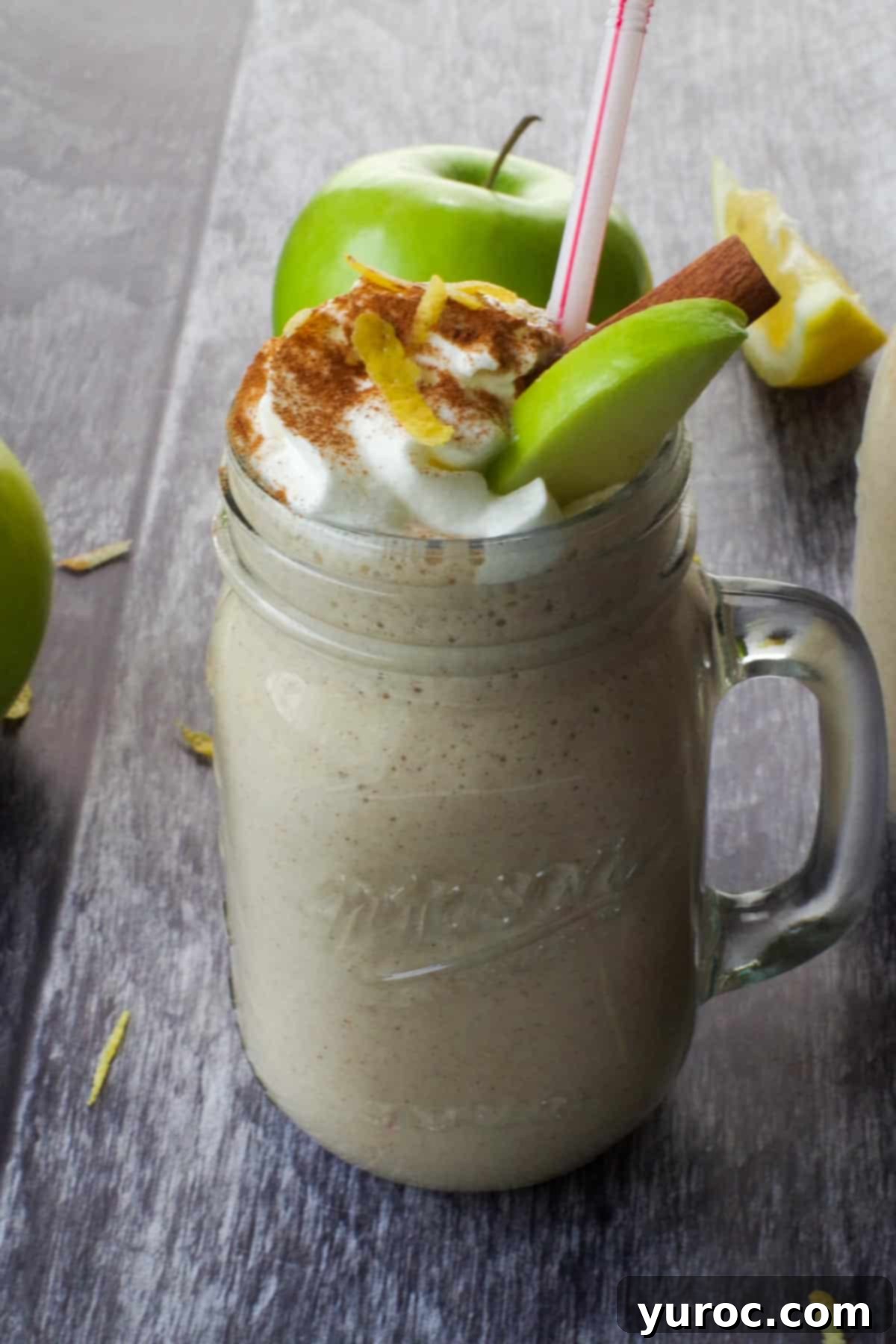 Wholesome Apple Pie Spice Blend 12 Healthy apple pie smoothie garnished with an apple slice, with fresh apples in the soft background, inviting a refreshing sip.
