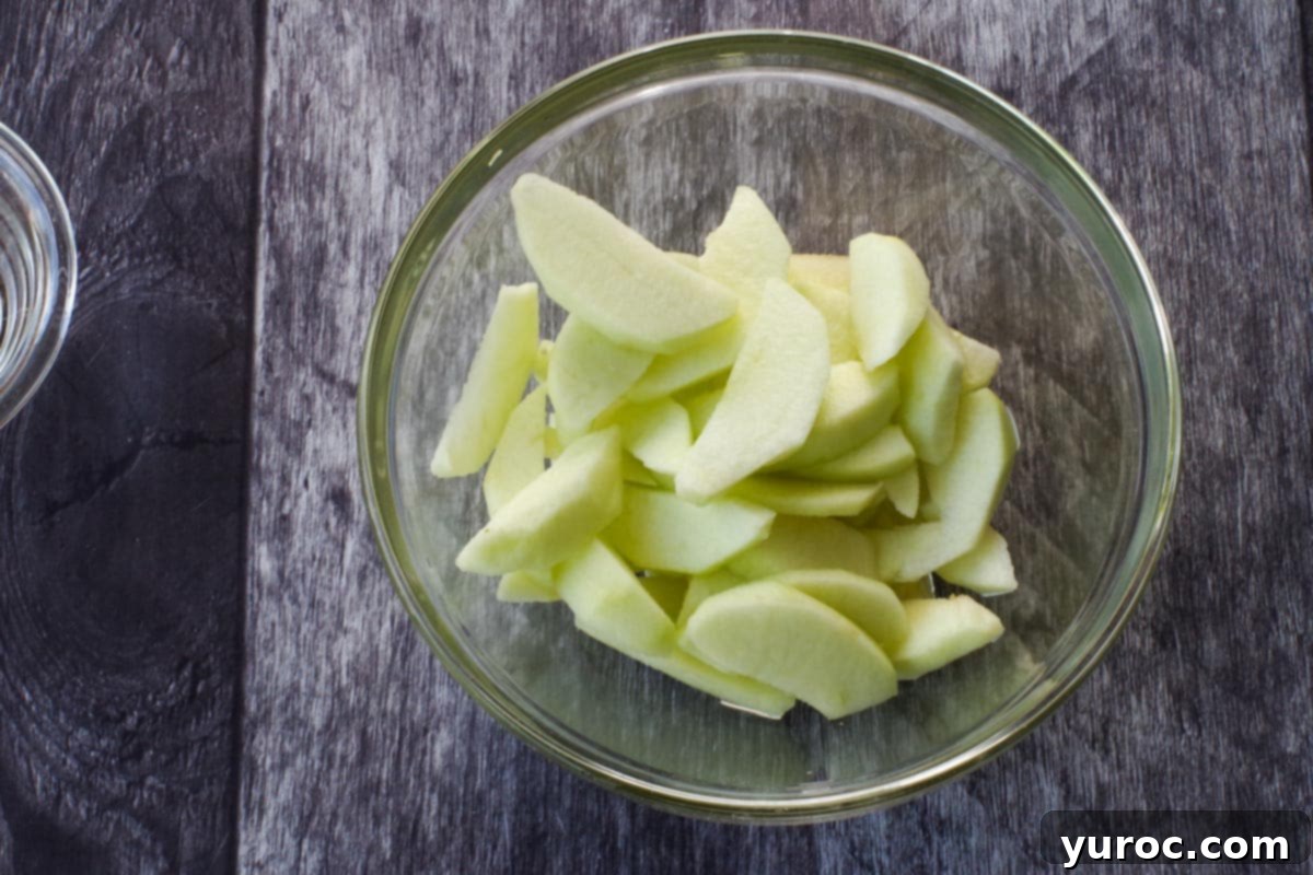 Wholesome Apple Pie Spice Blend 4 Sliced apples in a glass bowl, ready for cooking to soften and sweeten them.