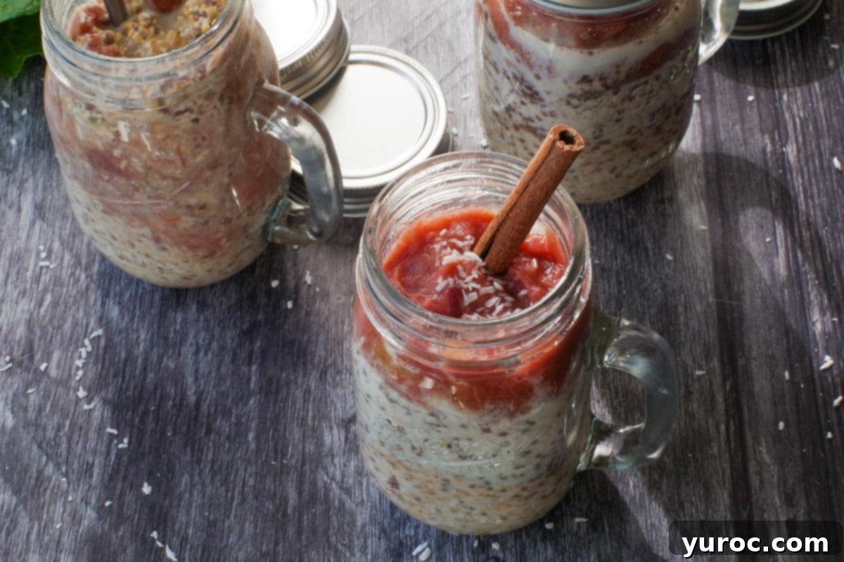 Two jars of creamy Rhubarb Overnight Oats, topped with fresh rhubarb slices and a sprinkle of coconut, ready for a healthy breakfast.