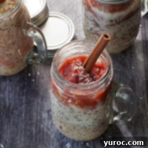 Two jars of creamy Rhubarb Overnight Oats, topped with fresh rhubarb slices and a sprinkle of coconut, ready for a healthy breakfast.