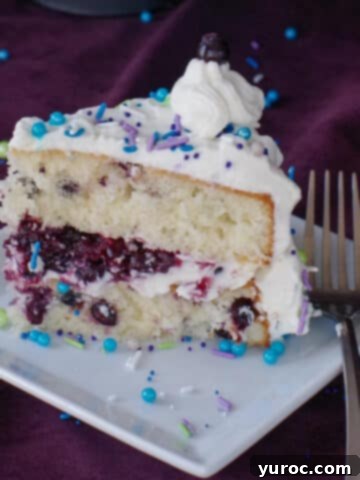a piece of Saskatoon berry cake on a white plate with a fork