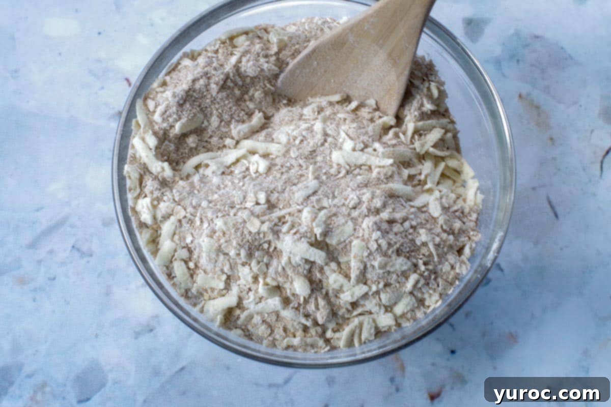 Saskatoon Berry Bliss Bars 9 butter mixed with dry ingredients in a glass bowl with wooden spoon