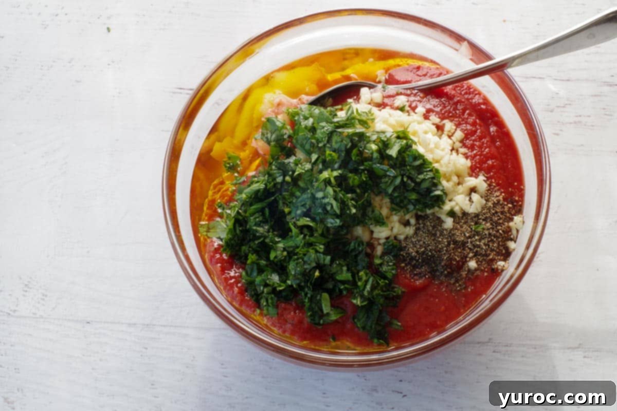 all bruschetta ingredients in a glass mixing bowl with a spoon