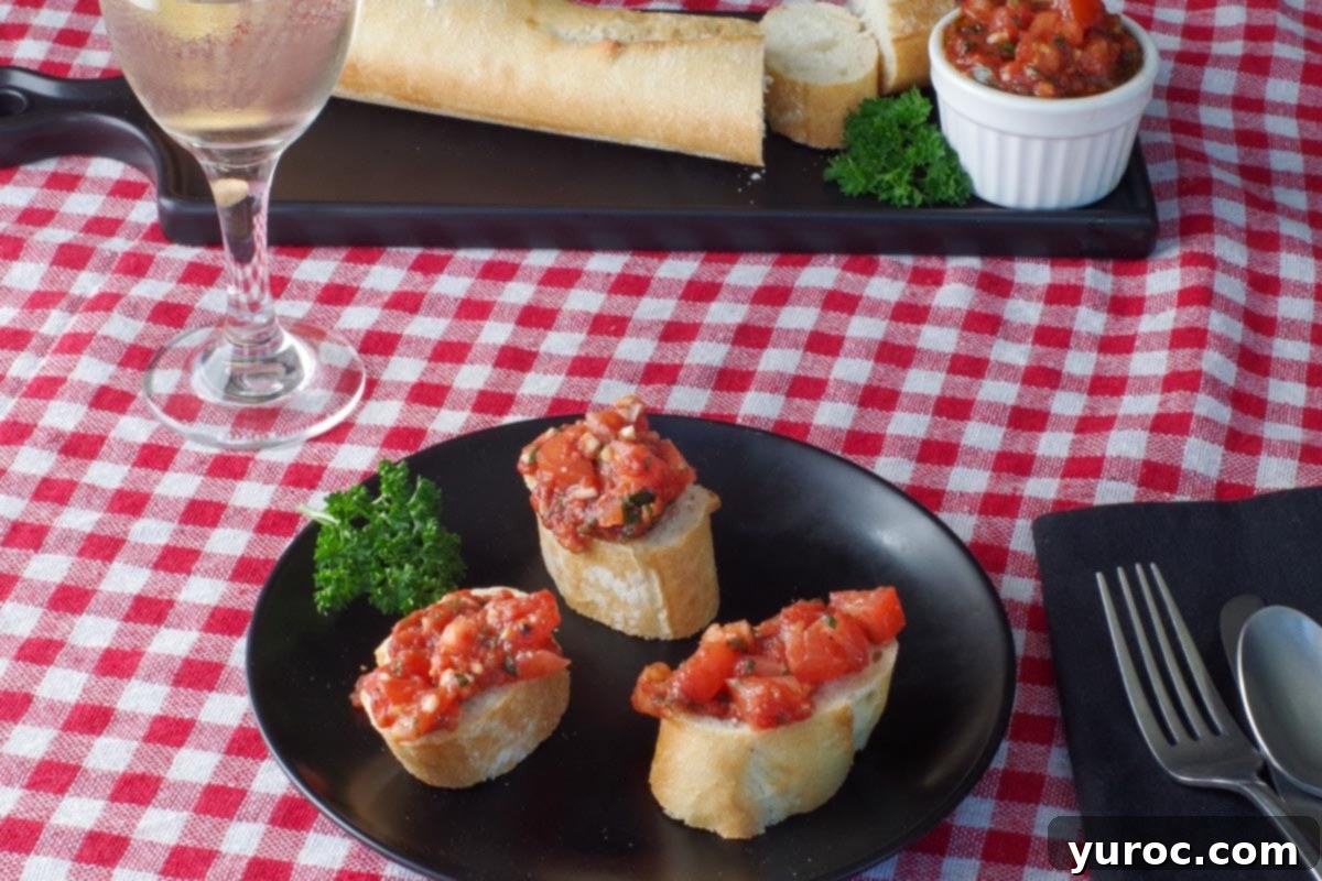 3 pieces of bread with bruschetta on a black plate with a baguette and bruschetta in the background