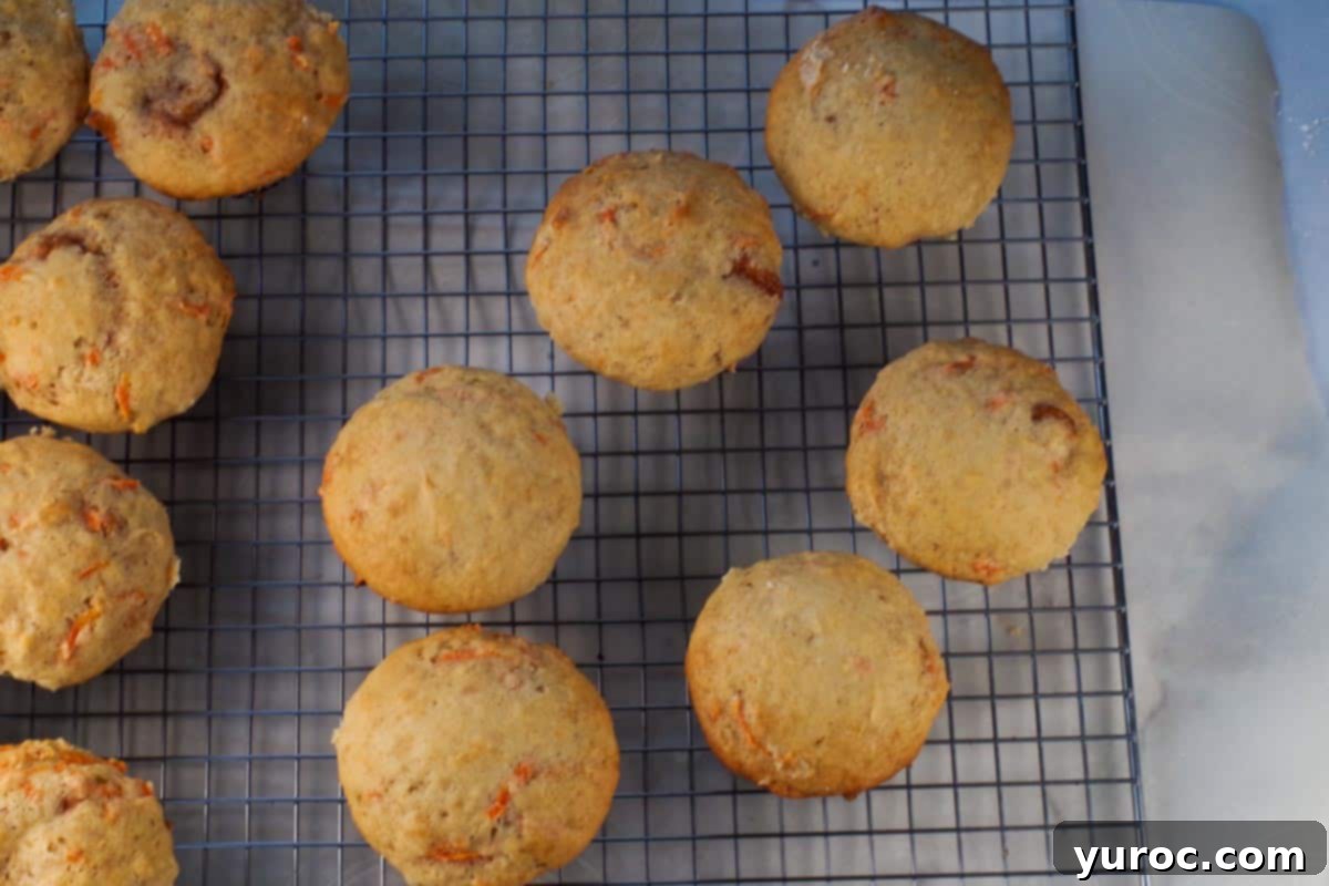 Glazed Carrot Cake Doughnut Muffins 15 Freshly baked muffins cooling on a wire rack.