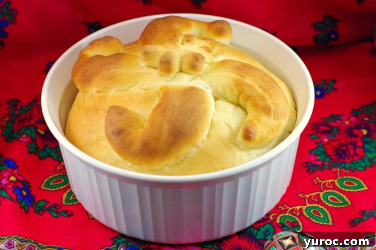 Perfectly baked Paska bread made in a bread machine, presented in a classic round white corningware casserole dish.