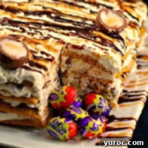 easter creme egg cake on white tray with slice removed and whole easter creme eggs in spot where slice is removed