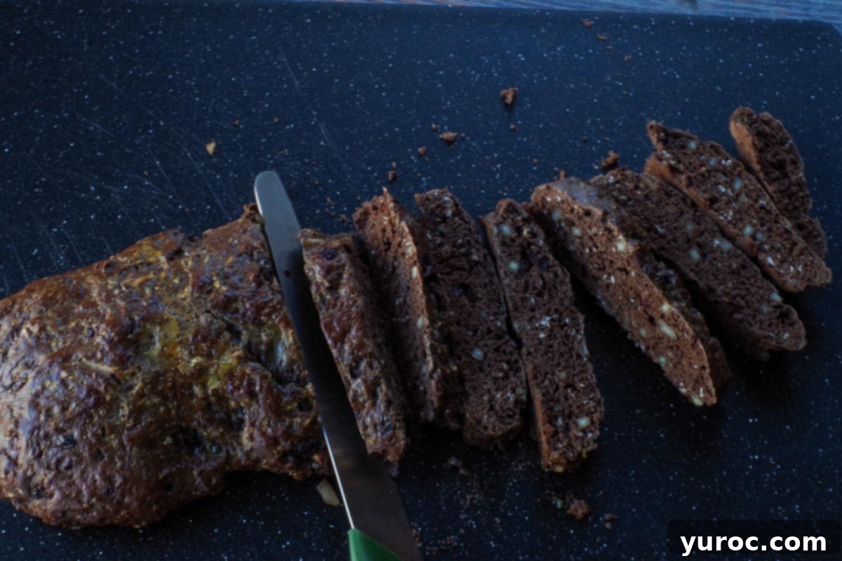 biscotti being sliced on cutting board with serrated knife