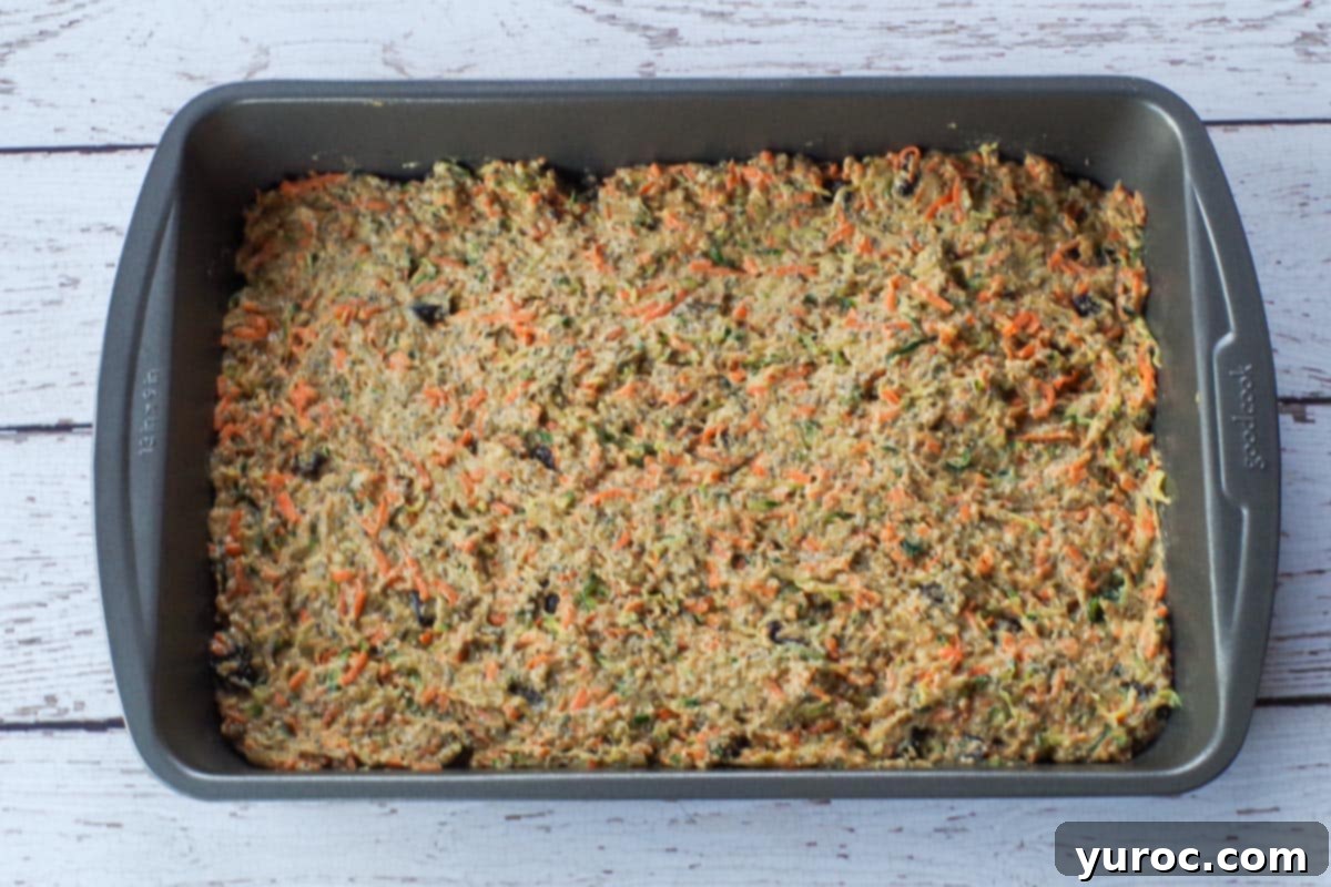 Zucchini bar batter smoothly spread into a 9x13 inch baking pan, ready for baking.