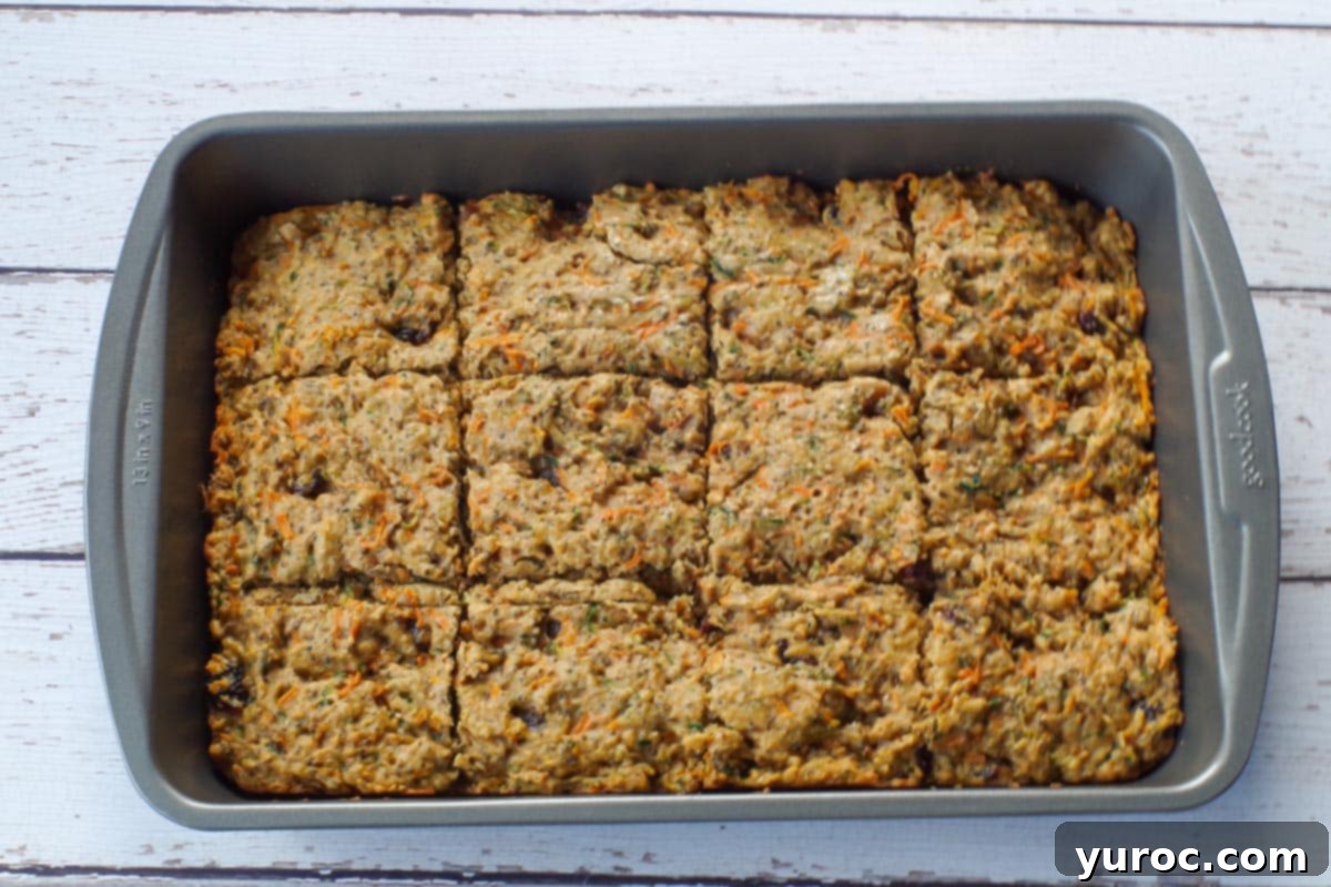 Baked zucchini bars, perfectly golden and cut into squares within the pan.