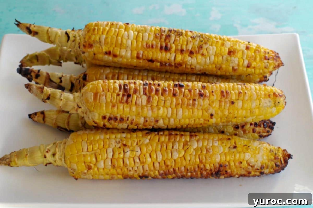 grilled corn on the cob on a white platter