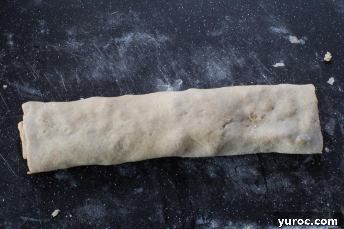 apple rolled up in scone dough on cutting board