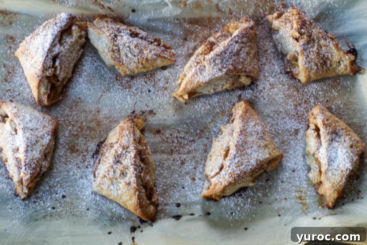 baked scones on parchment paper, sprinkled with powdered sugar