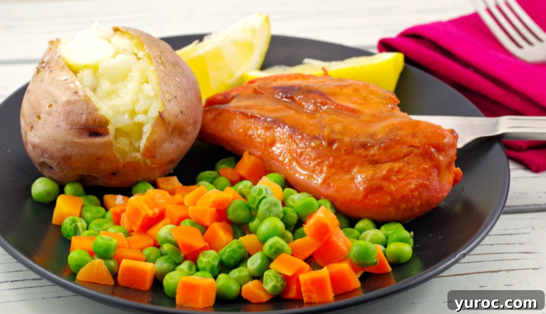 Monterey chicken on plate with baked potato and mixed vegetable