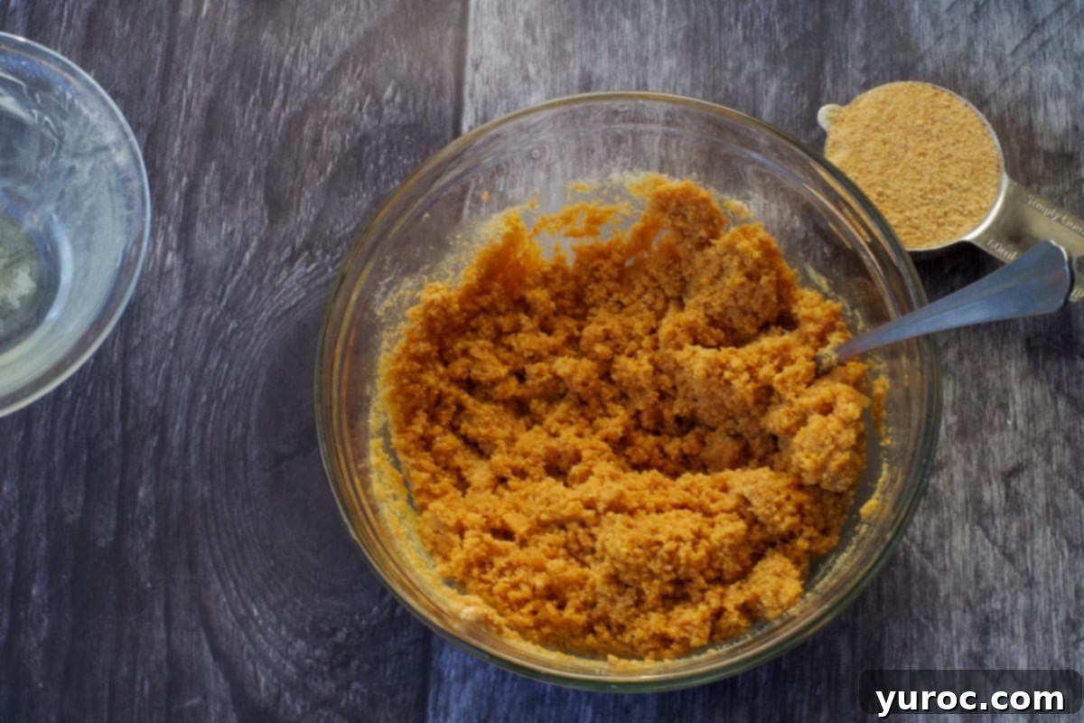 Effortless Pumpkin Perfection 4 A glass bowl containing a perfectly mixed graham cracker crumb mixture, ready for the baking pan.