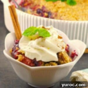 Triple Berry Crisp with frozen berries in a white dish, with more in a baking dish in the background.