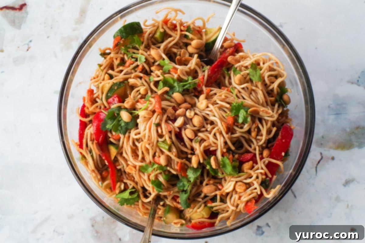 Leftover Spaghetti Peanut Salad 6 Dressing mixed into peanut pasta salad in a large glass bowl