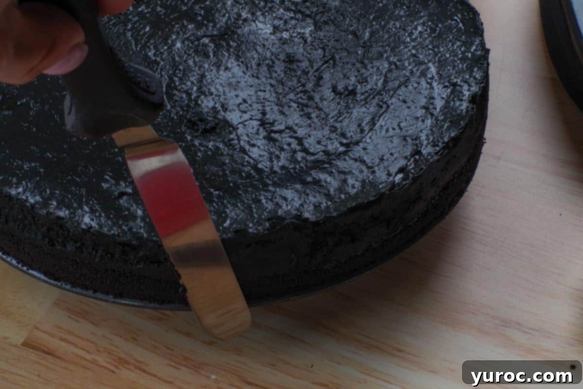 cheesecake sides being smoothed with decorating spatula