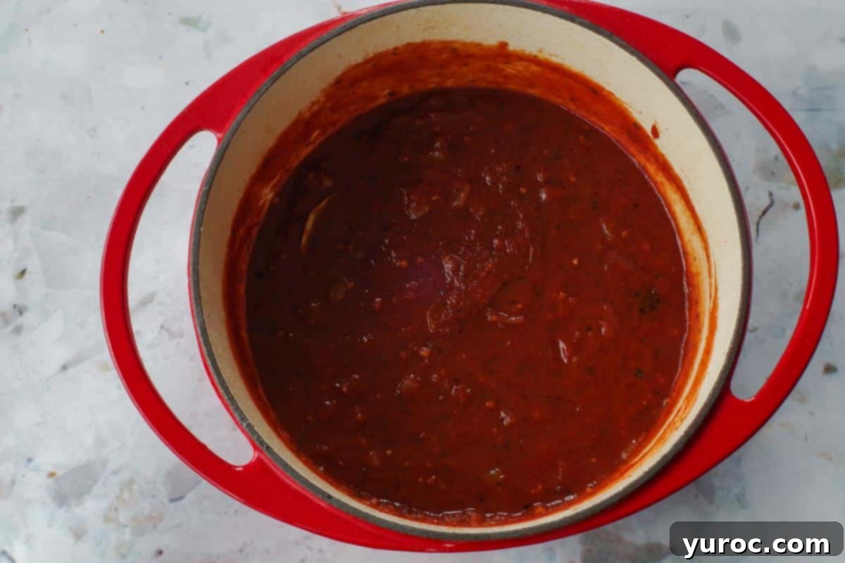Tomato sauce and paste added to onion mixture in Dutch oven,