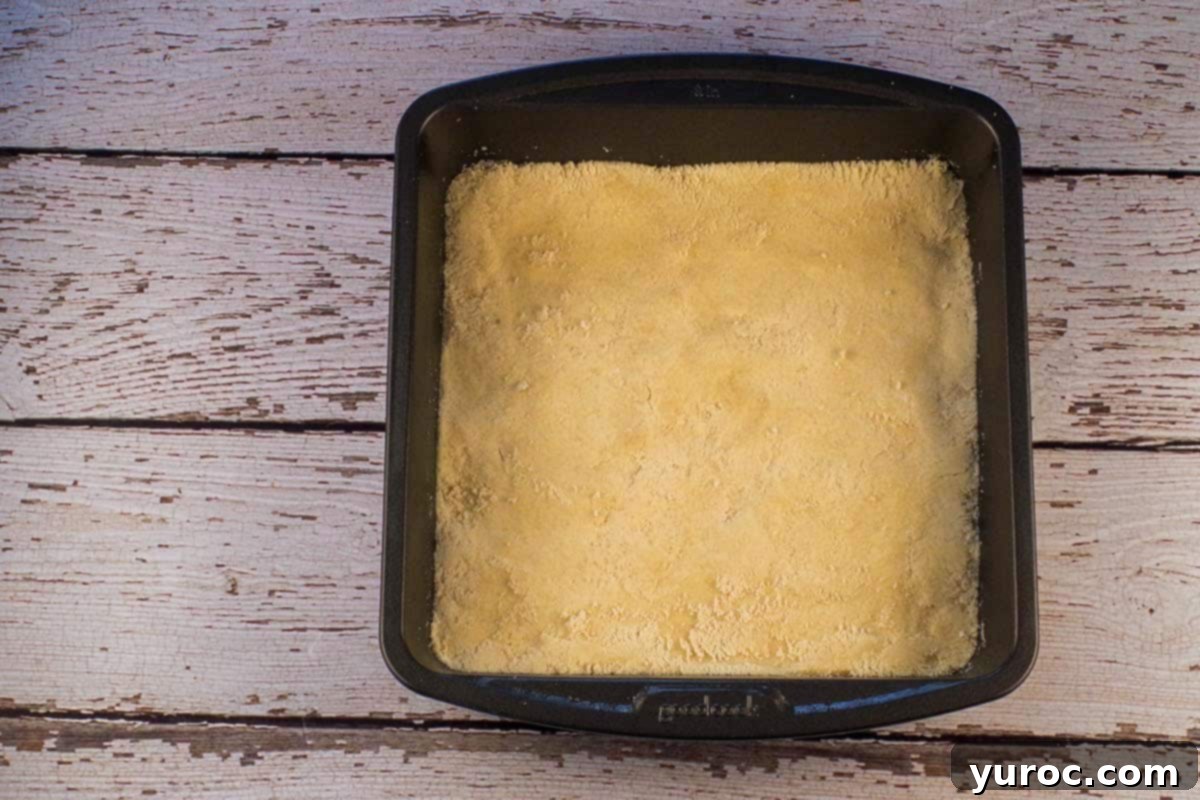 Shortbread base mixture pressed evenly into the prepared square baking pan.