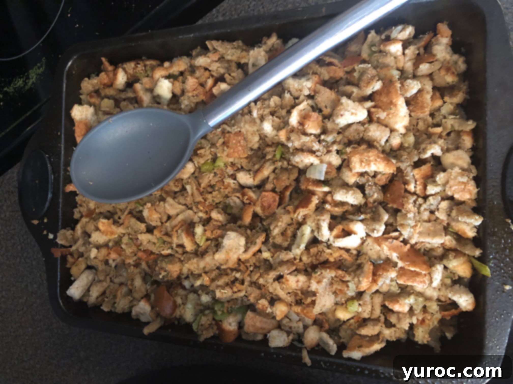 Adding prepared stuffing mixture to 9X13 inch baking pans for separate baking.