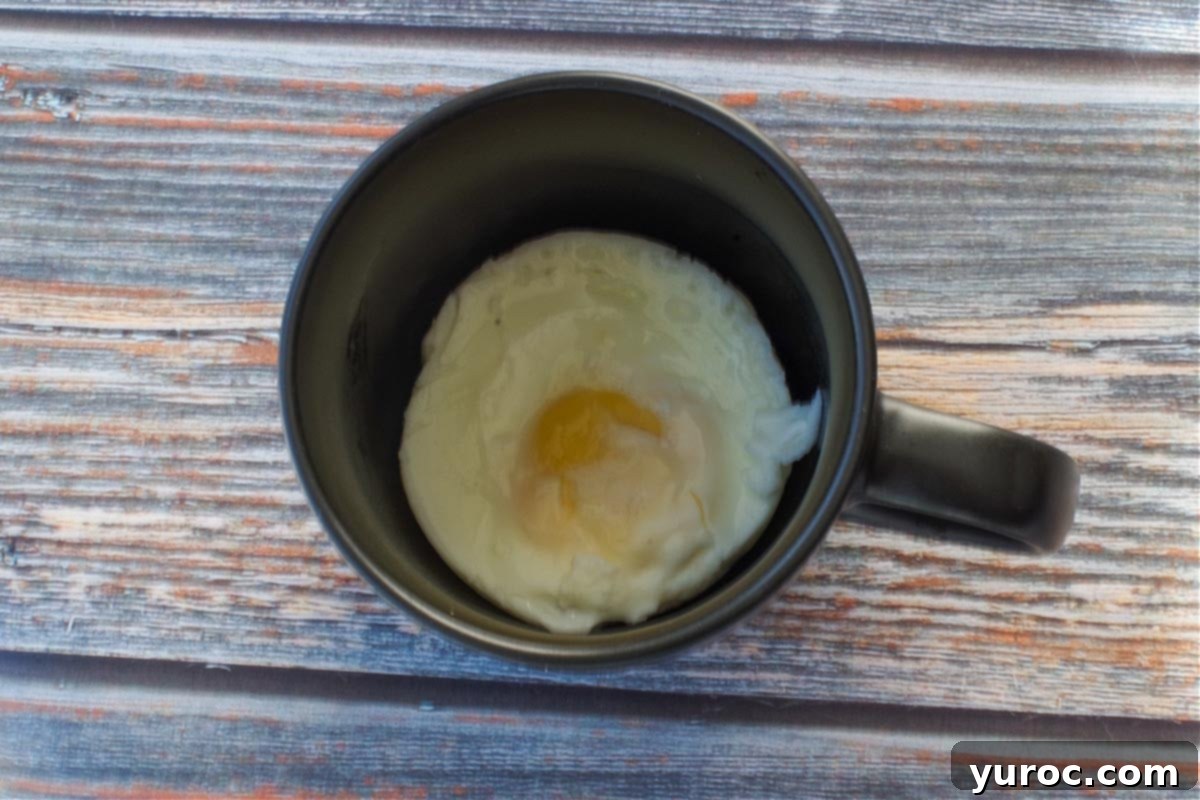 Cooked egg in black mug.