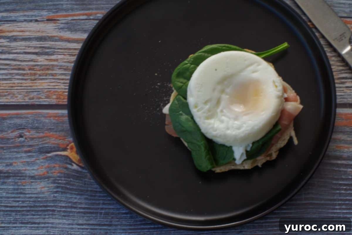 Poached egg on spinach and prosciutto covered English muffin.