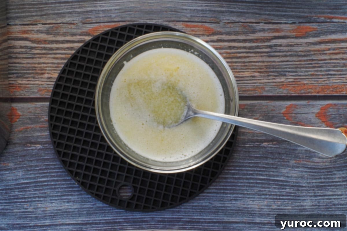 Butter and oil mixed together in a small glass bowl with spoon.