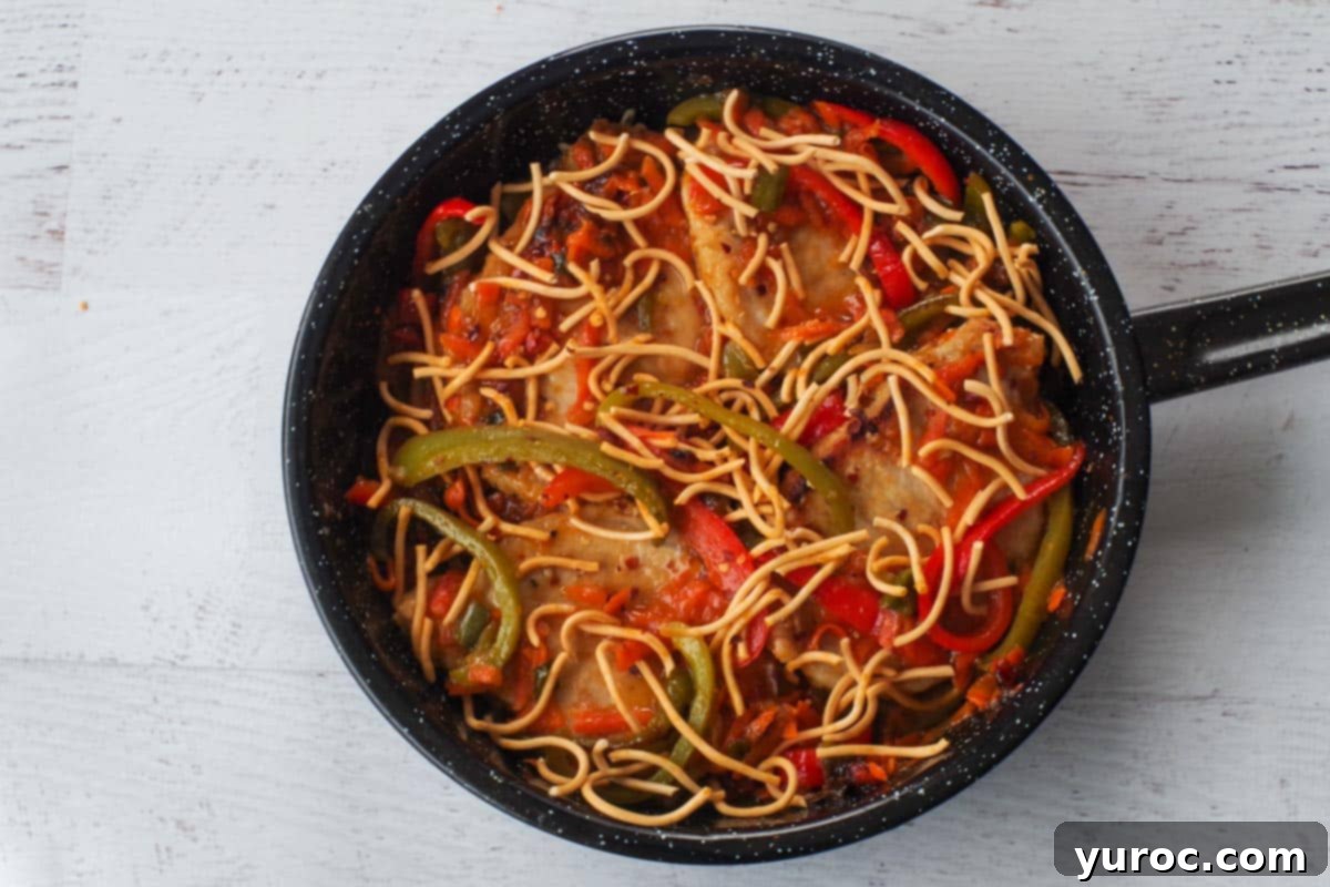 Plum Sauce Pork garnished with crispy chow mein noodles in the frying pan.