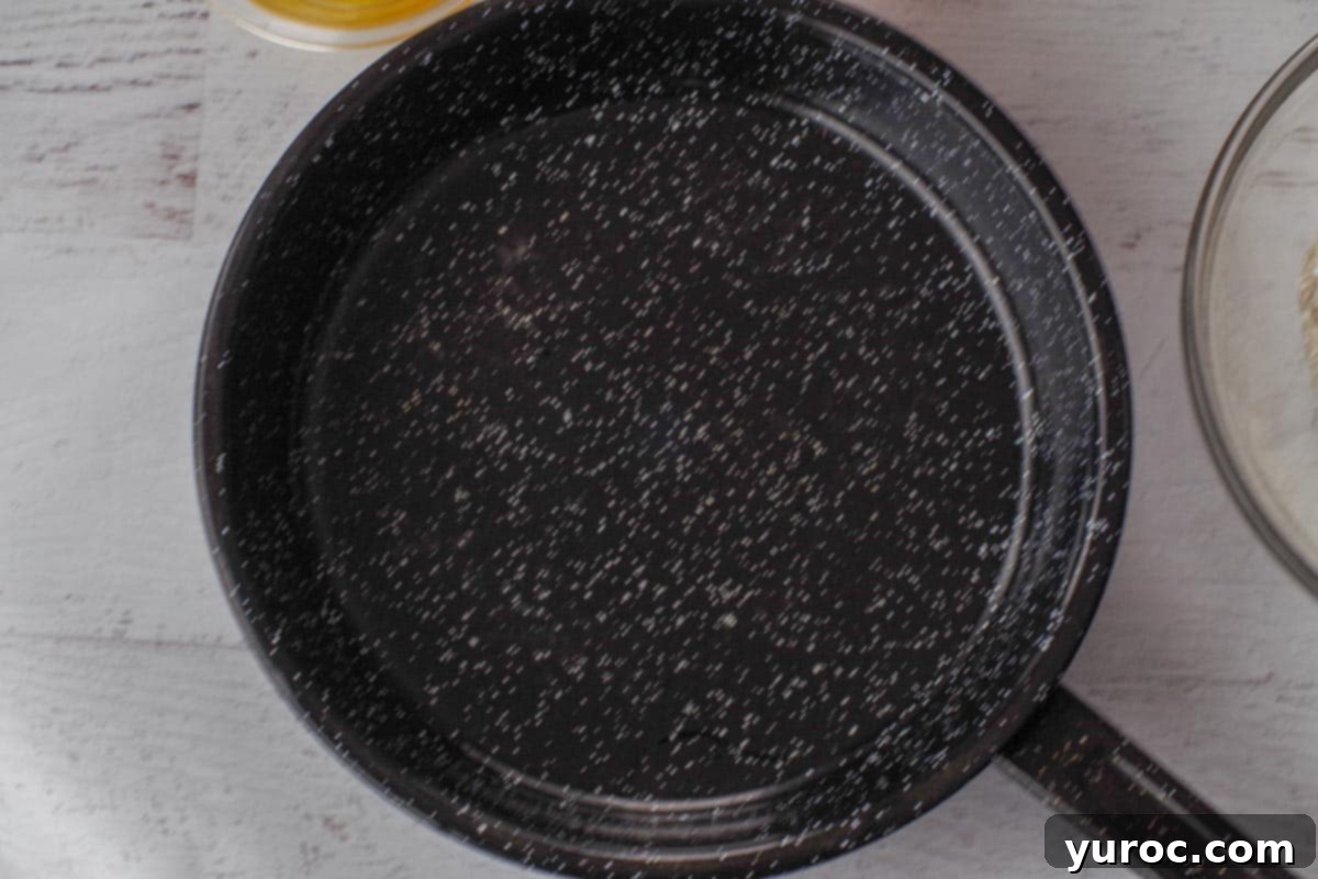 Olive oil being heated in a non-stick skillet over medium-high heat.