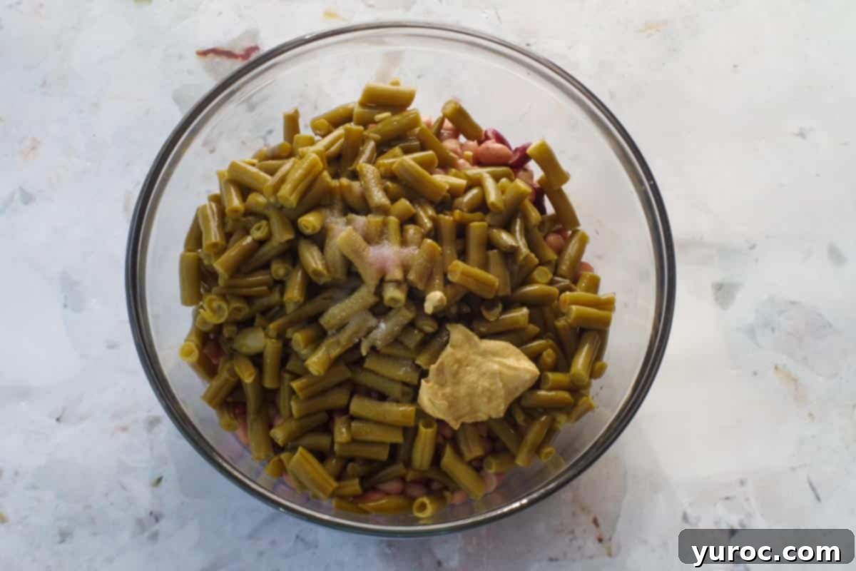 Effortless Mixed Bean Salad 5 All ingredients in bean medley salad in a large glass bowl.