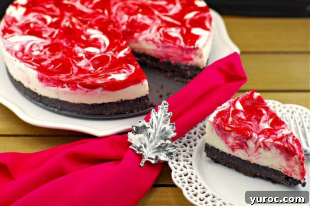 A slice of No Bake Strawberry Rhubarb Cheesecake on a white plate with a red napkin and Canadian flag napkin ring, with the rest of the cake in the background.