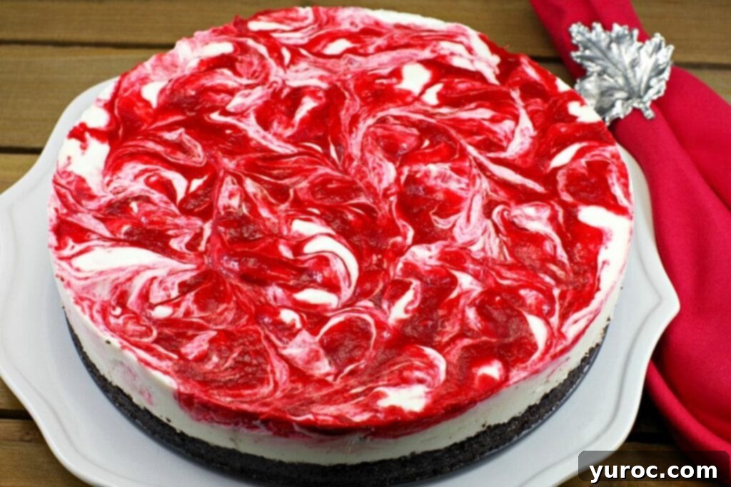 A beautifully presented whole no bake strawberry rhubarb cheesecake on a white plate, ready to be served.